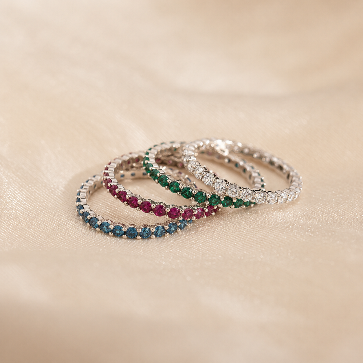 Three rings with gemstones on a beige surface